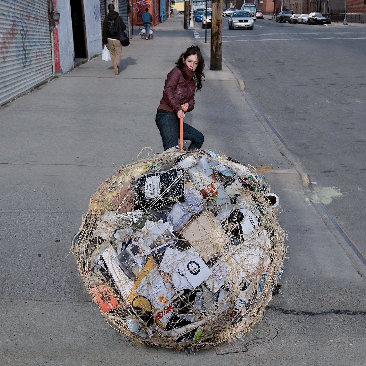 Artist Mary Mattingly pulling a large bundle of objects, performance art, contemporary art, modern art, soft sculptures, bundle sculptures, wall art prints, performance art, wall decor, art cafe, robert smithson, minimalist art, art house, framed prints, giclee prints, geometric art, art shop, contemporary art print